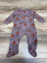 Flat view of Carter’s mauve footed sleeper in size 9 months showing long sleeves and dog and beanie print on a wood grain background