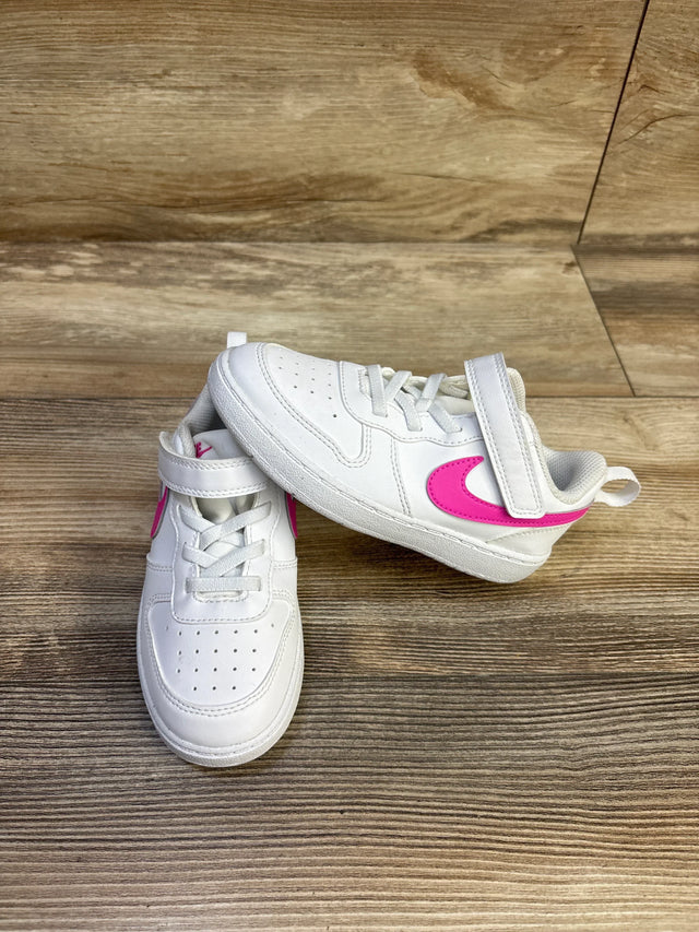 Angled front and side view of toddler Nike Court Borough Low Recraft sneakers showcasing white leather and laser fuchsia Swoosh with wood floor background