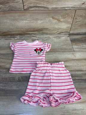 Flat lay of Disney Baby 2pc set showcasing pink striped Minnie Mouse top with ruffle sleeves and ruffle-hem shorts on wood plank floor