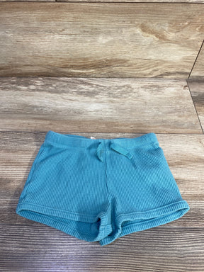 Front view of teal toddler waffle-knit shorts (size 18M) showcasing elastic drawstring waist and rolled cuffs on wood background