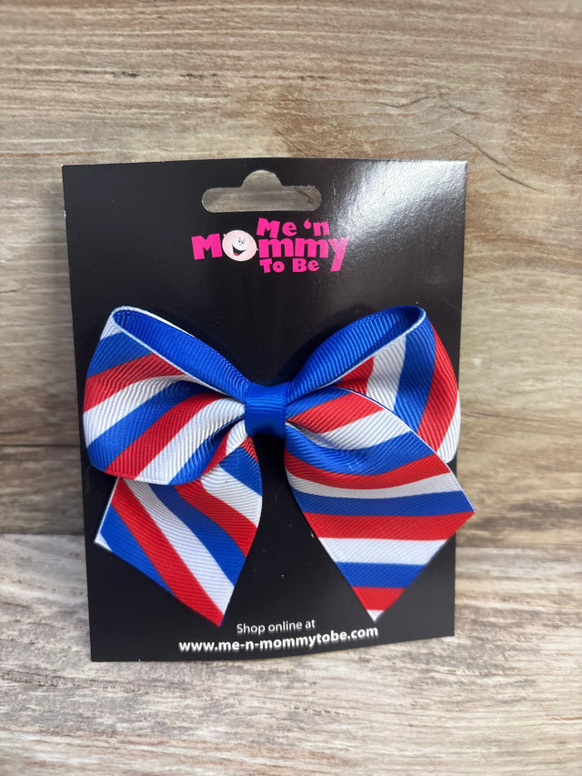 Front view of NEW Fourth Of July Striped Hair Bow showcasing red white and blue diagonal grosgrain stripes on Me n Mommy To Be branded card backing on wood plank floor