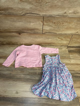 Girls' pink cardigan and floral sleeveless dress set on wood background, kids clothing