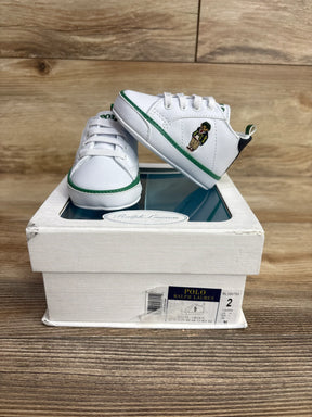White and green Polo Ralph Lauren baby shoes with bear embroidery on shoe box on wood surface