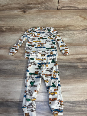 Toddler pajama set with animal and car print, long sleeve top and pants on wood floor