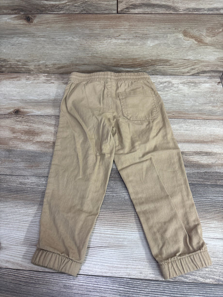 Tan H&M pull-on drawstring joggers for toddlers size 3T on a wood background