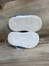 Pair of toddler shoes with white star-patterned soles on wood surface