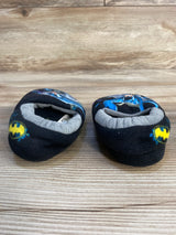 Black baby slippers with Batman logos on wooden floor