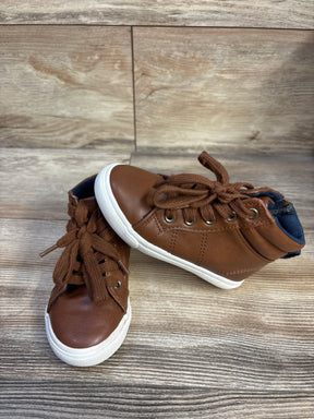 Three-quarter view of Cat & Jack toddler brown high-top sneakers showing laces, white rubber soles and navy lining on wood floor
