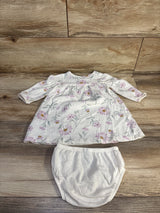 Top-down view of Carter's 2-piece white henley dress with pink floral print and matching white bloomers on wood background