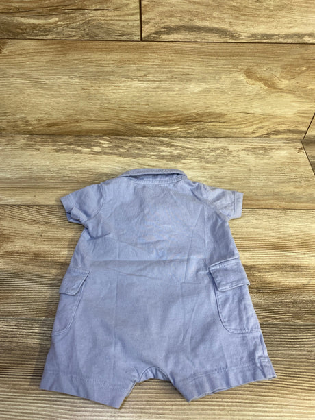 Back view of blue Carter's polo henley baby romper showing collar and flap side pockets on wood background