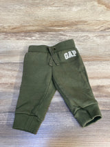 Olive green baby jogger pants with GAP logo, kids clothing on wood background