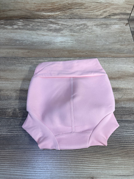 Top-down view of Splash About Happy Nappy pink swim diaper showcasing folded waistband, center seam, and leg cuffs on wood plank background