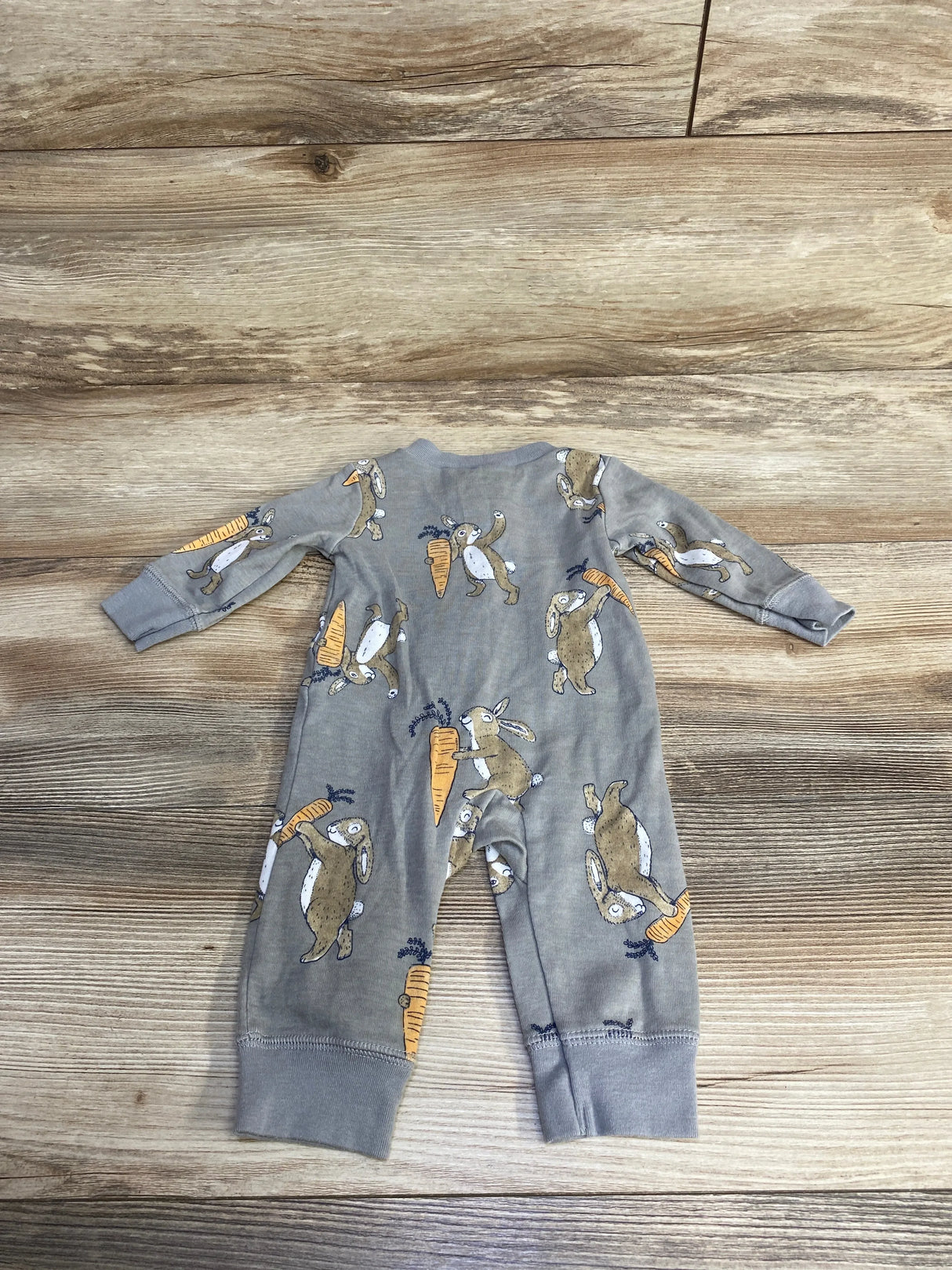 Flat lay of Carter's grey bunny-print baby jumpsuit size 3M showing long sleeves and cuffed legs on wood floor