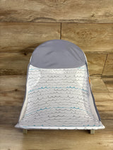 Front view of Summer Deluxe Baby Bather in grey showcasing breathable mesh seat with scalloped wave print on wood floor background