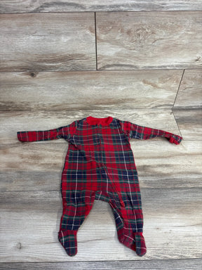 Red and green plaid baby footed pajamas with zipper, laid on wood floor