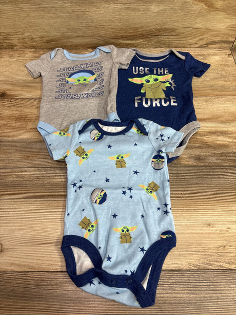 Top view of Happy Threads x Star Wars 3-pack blue bodysuits, size 6/9 months, with Grogu designs on a wood surface