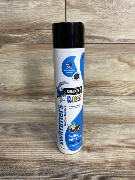 Front view of Sharkey's Swimmer's Clarifying Shampoo bottle showcasing Sharkey's Kids logo on a wood background