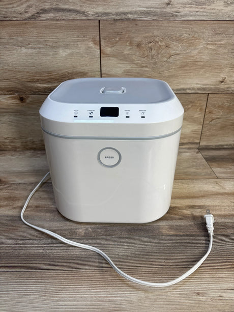 White baby bottle sterilizer with lid and power cord on wood floor background