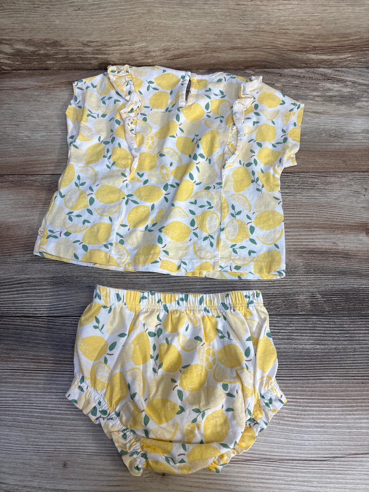 Baby girl lemon print ruffle top and bloomer set on wooden background