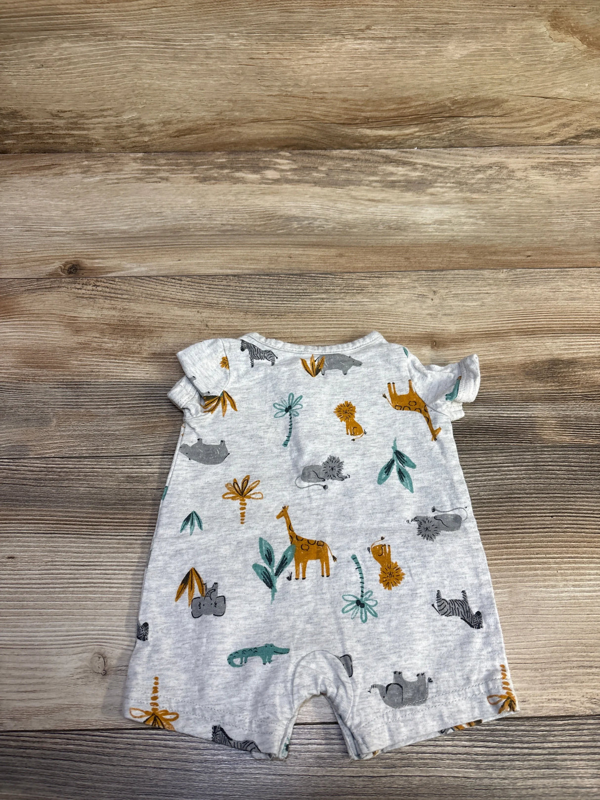Back flat lay of grey newborn Henley shortie romper showing all-over safari animal print and ruffle sleeves on wood background