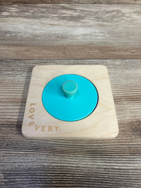 Lovevery wooden circle puzzle with turquoise knob on wood background