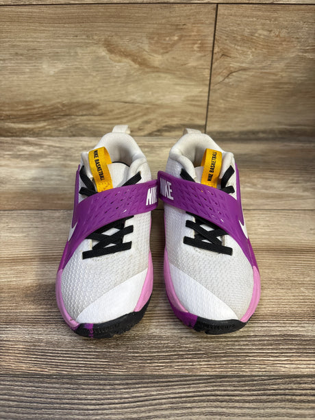 Front view of toddler Nike Team Hustle D sneakers with purple NIKE strap, white mesh upper, black laces, yellow tongue tab on wood floor size 11C