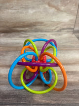 Colorful plastic baby teething toy with loops in blue, orange, green, and purple on wooden surface