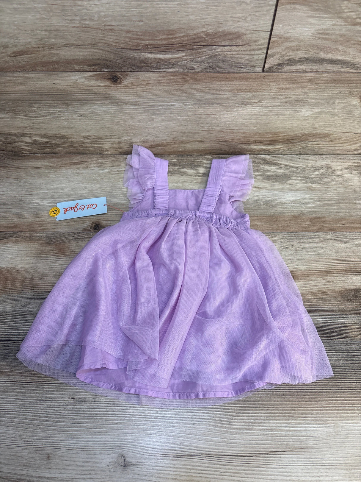Light purple toddler dress with ruffle sleeves on wood background, gently used kids clothing