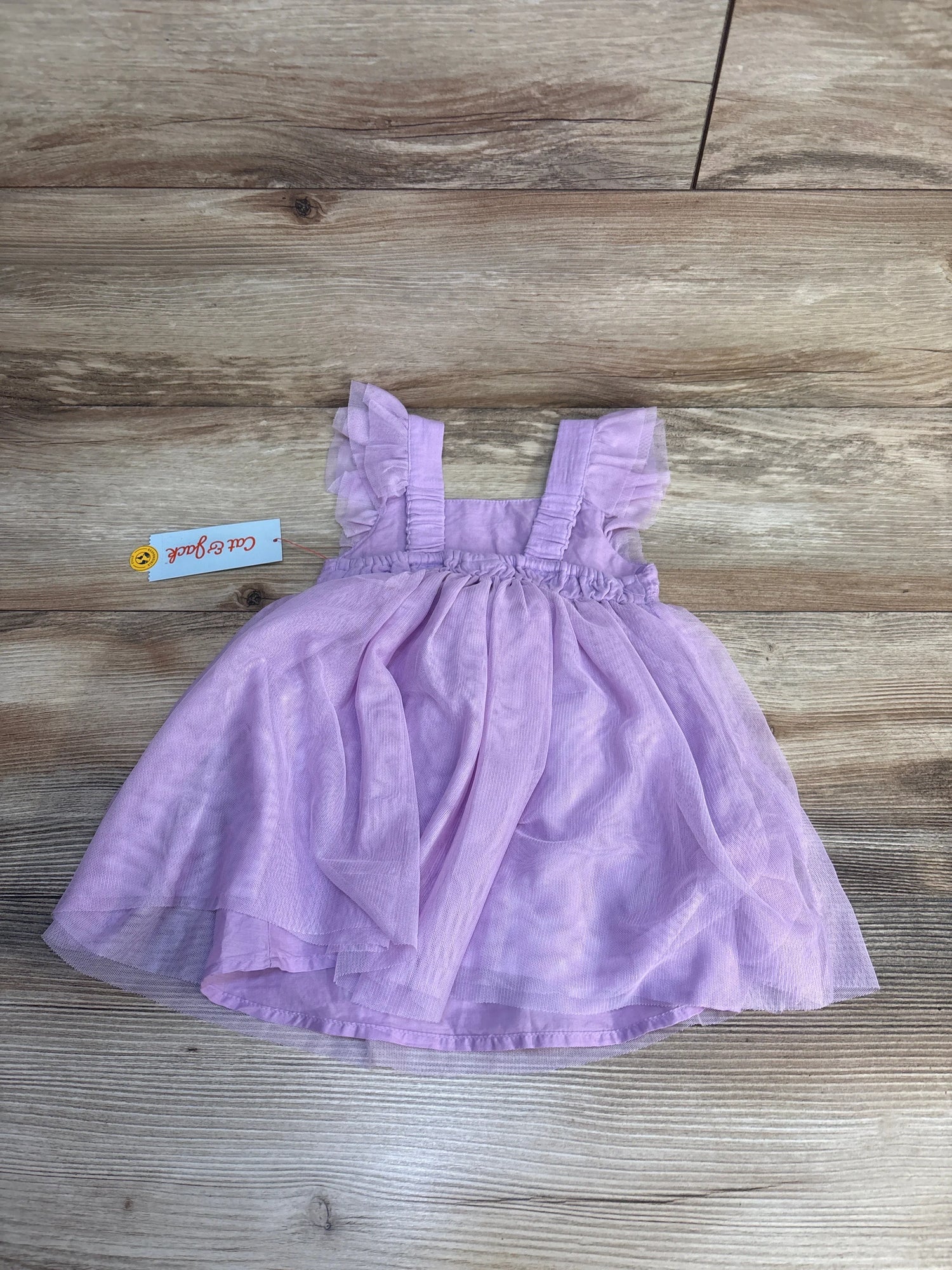 Light purple toddler dress with ruffle sleeves on wood background, gently used kids clothing