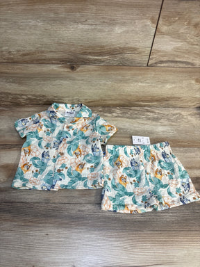 Colorful toddler shirt and shorts set with animal and leaf print on wood background