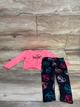 Front flat-lay of Hurley pink long-sleeve top knotted at hem and black leggings with colorful heart logo print on wood