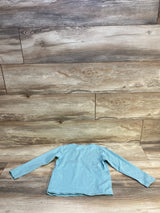 Light blue long sleeve kids shirt, back view, on rustic wood background