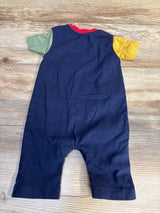 Navy blue baby romper with green and yellow short sleeves on wood background