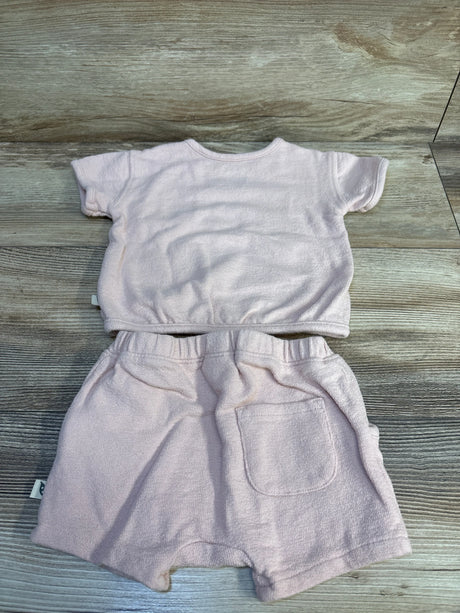 Flat lay of pink Easy Peasy two-piece baby set showing terry fabric, elastic waist and back pocket on light wood floor