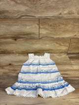 White and blue sleeveless toddler dress with cityscape print on wooden background
