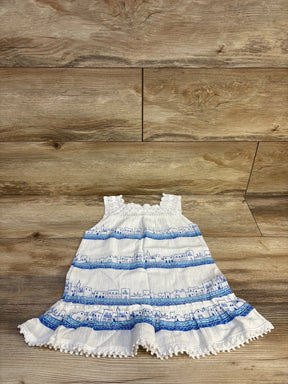 White and blue sleeveless toddler dress with cityscape print on wooden background