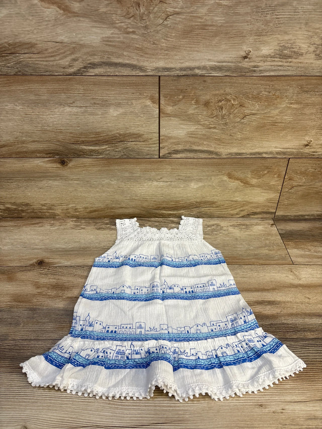White and blue sleeveless toddler dress with cityscape print on wooden background