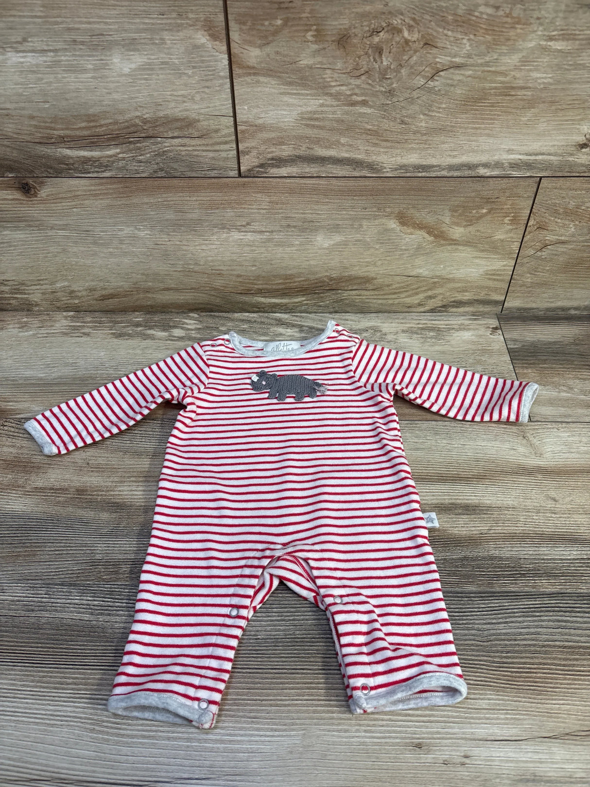 Front view of red-and-white striped Albetta romper with grey crochet rhino applique and snap legs on wood background