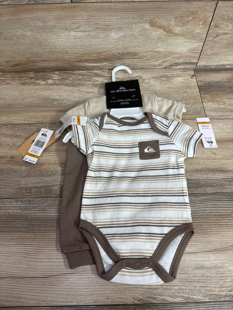 Flat lay of Quiksilver newborn 3-piece set: striped tan bodysuit with snap closures and tan joggers on wood background