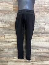 Front view of black drawstring maternity joggers showing waistband and tapered legs on wood plank background