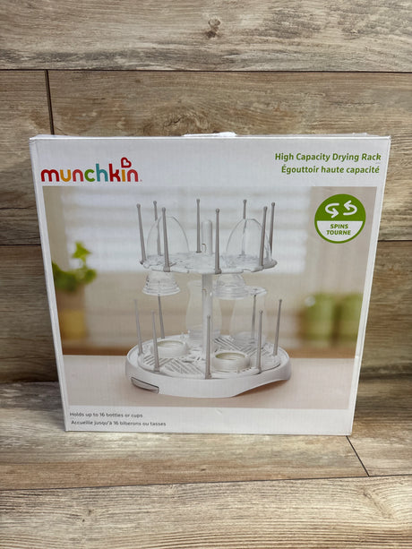 Front view of Munchkin high-capacity bottle drying rack box showing two-tier spinning white rack that holds up to 16 bottles on wooden background