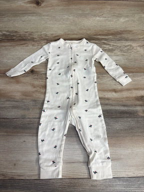 White baby onesie with holly berry print, long sleeves, full zipper, laid on wood floor