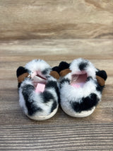 Fuzzy cow print baby shoes with ears, soft sole, on wooden background