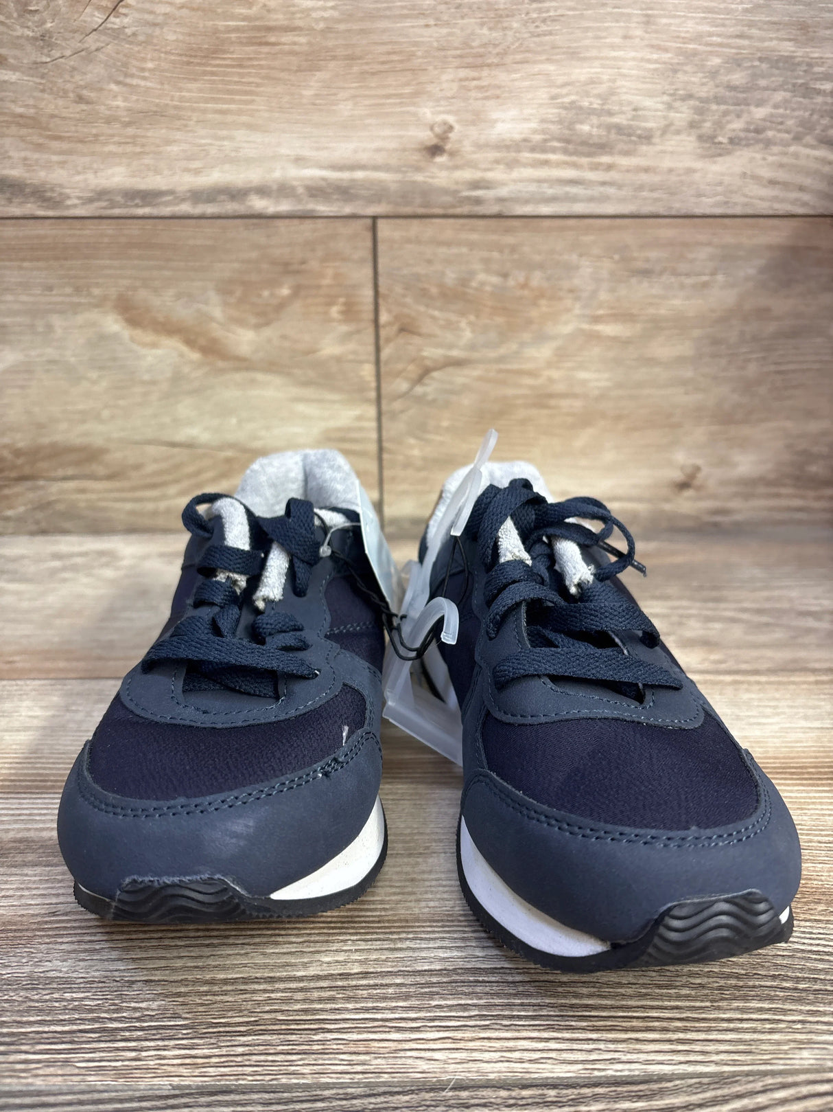 Front view of Cat & Jack Jax toddler sneakers, navy blue lace-up with white midsole, on wood floor