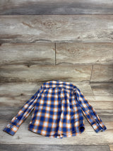 Kids long sleeve blue and orange plaid shirt laid flat on wood floor