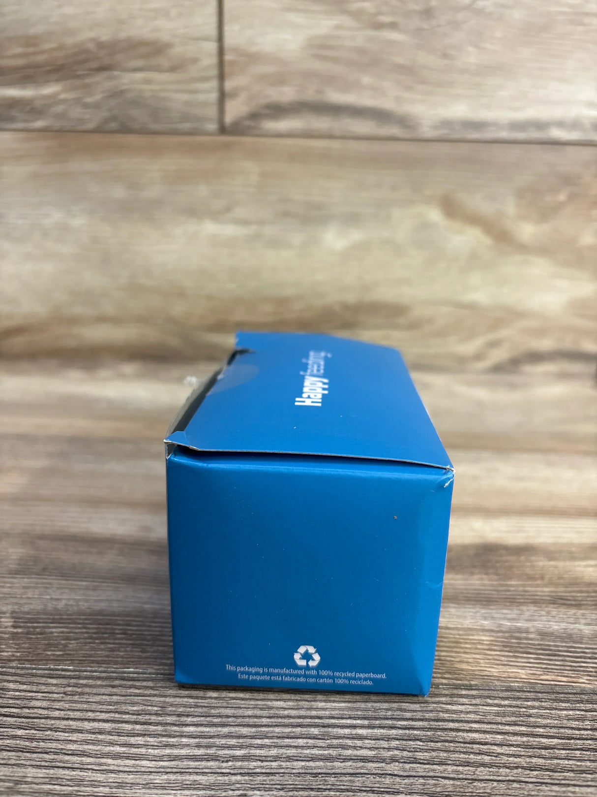 End view of blue Dr. Brown's Milestones silicone narrow baby bottle handles 3-pack box showing recycling symbol on wood surface