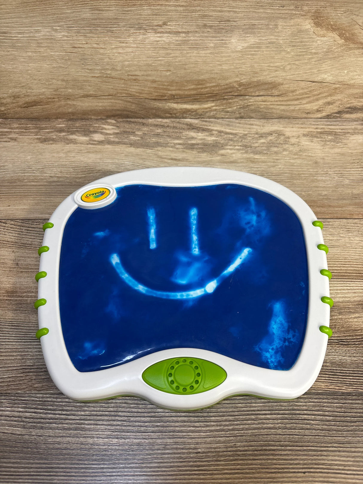 Crayola kids drawing board with blue surface, smiley face, on wood background