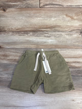 Flat lay of Rylee + Cru olive toddler shorts showing drawstring waist and front pockets on light wood background