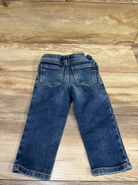 Back view of Okie Dokie drawstring jeans in blue showcasing two back pockets and cuffed hems with wood background