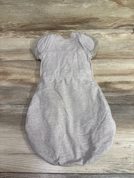 Front view of Nested Bean Zen One Classic Convertible Swaddle in beige showcasing short sleeves on a wood background